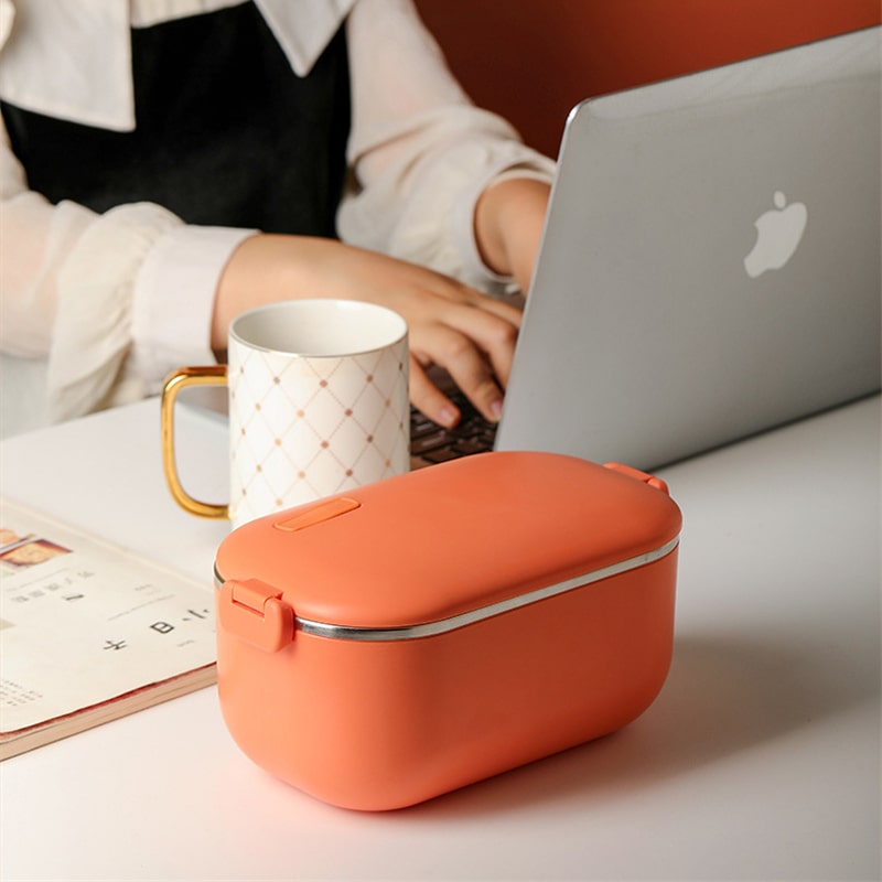 Lunch Box Chauffante Electrique Isotherme Inox Orange fermée à côté d'un ordinateur